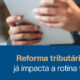 Profissional analisando dados fiscais em tablet e notebook, representando os impactos da reforma tributária de 2026 na rotina fiscal das empresas.